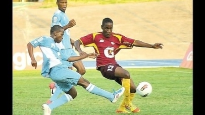 Cordel Benbow (left) shoots ahead of Andre Wilson of Wolmer’s (right) to score the opening goal for St George’s College during their ISSA/Digicel/Gatorade Manning Cup semi-final game at the National Stadium yesterday. St George’s won 2-0. (Photo: Garfield Robinson)