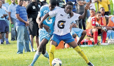 St George’s College’s Mark Brown (left) and Hydel High’s Gah-Seani Wray battle for possession during a Group C preliminary round match of the ISSA/Gatorade/Digicel Manning Cup.