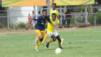 Romain Carthy (left) of STATHS being chased by Alton Lewis of Charlie Smith during their Flow/ISSA Group D Manning Cup game at the Anthony Spaulding Sports Complex. Charlie Smith won 3-0.