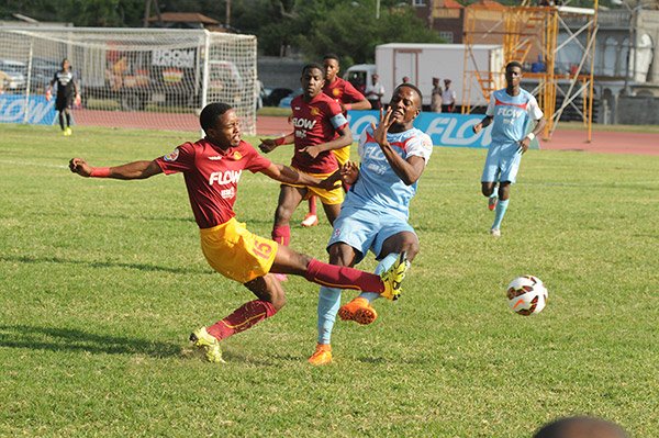 Jevauni Garwood (left) of Wolmer’s and Jevaun McKellar of St George’s College fight for possession of the ball during their ISSA Flow Walker Cup final at the Stadium East field.